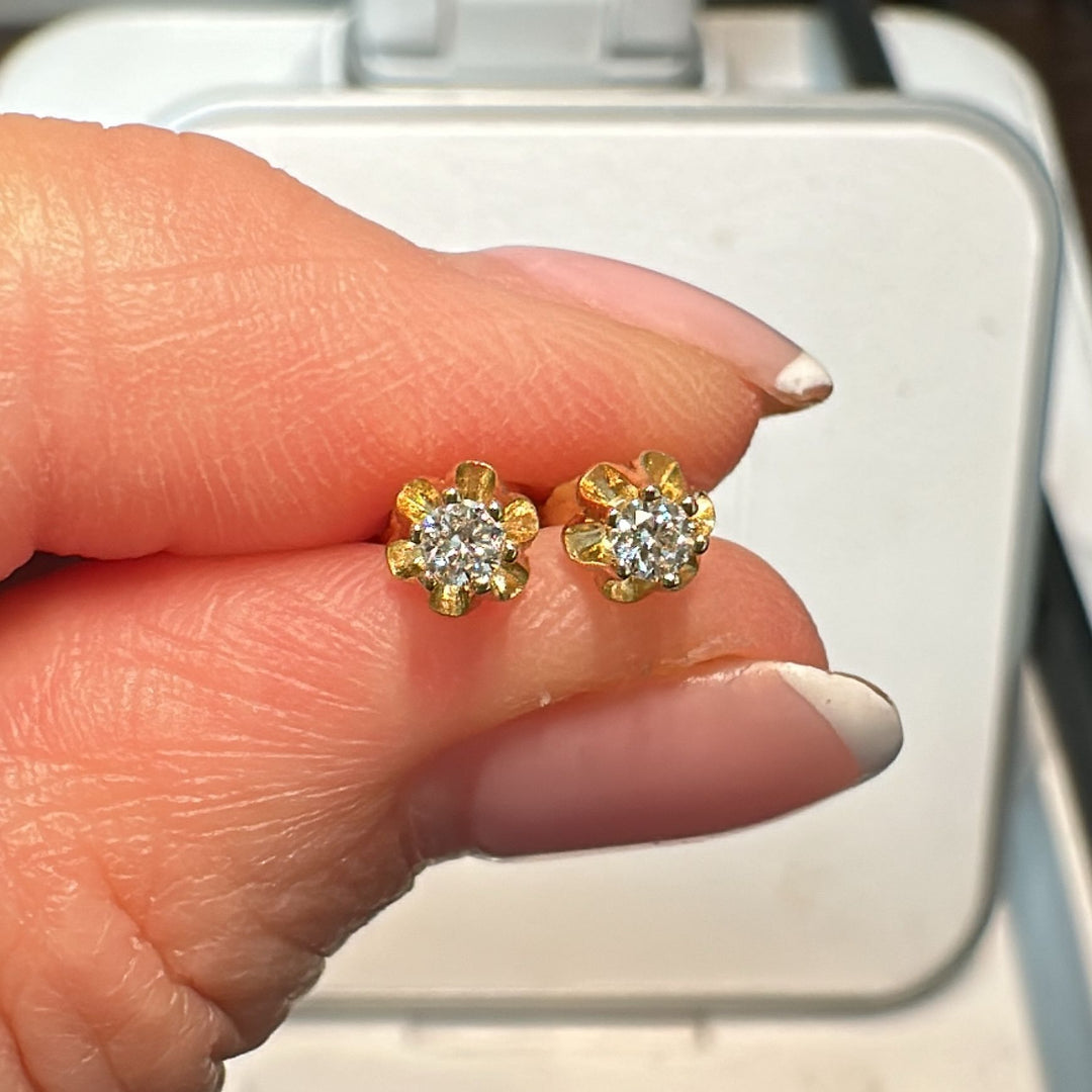 Natural diamond stud earrings in 14K yellow gold with floral prong setting.