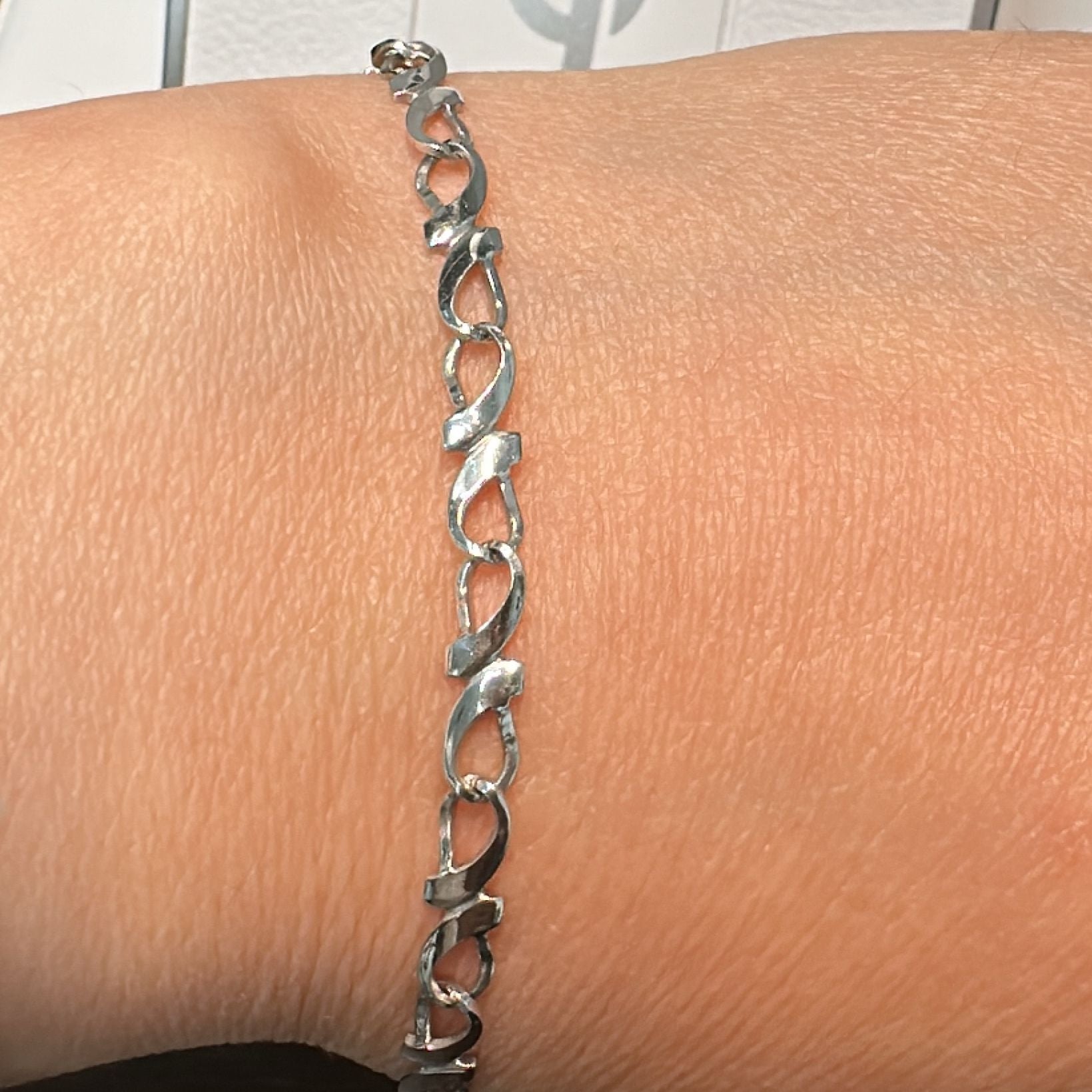 10K white gold twisted link bracelet, 4mm width, 7" length, with a lobster clasp.