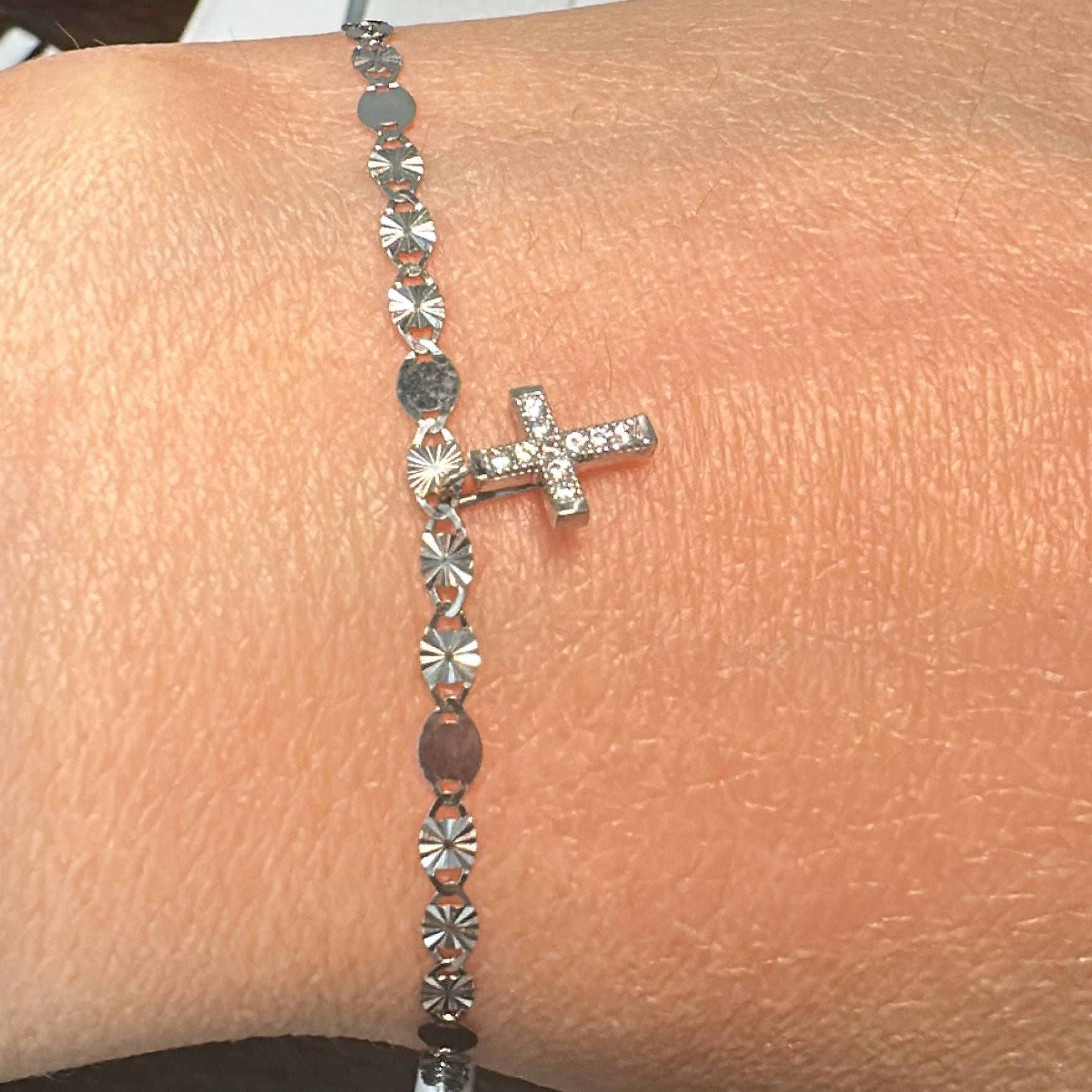 10K white gold bracelet with delicate cross charm and polished link design.