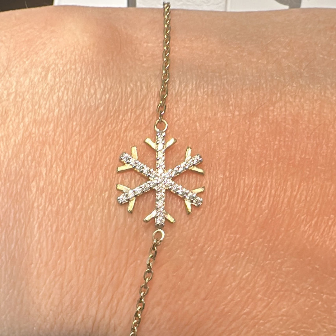 10K yellow gold bracelet with cubic zirconia snowflake charm on a delicate chain.