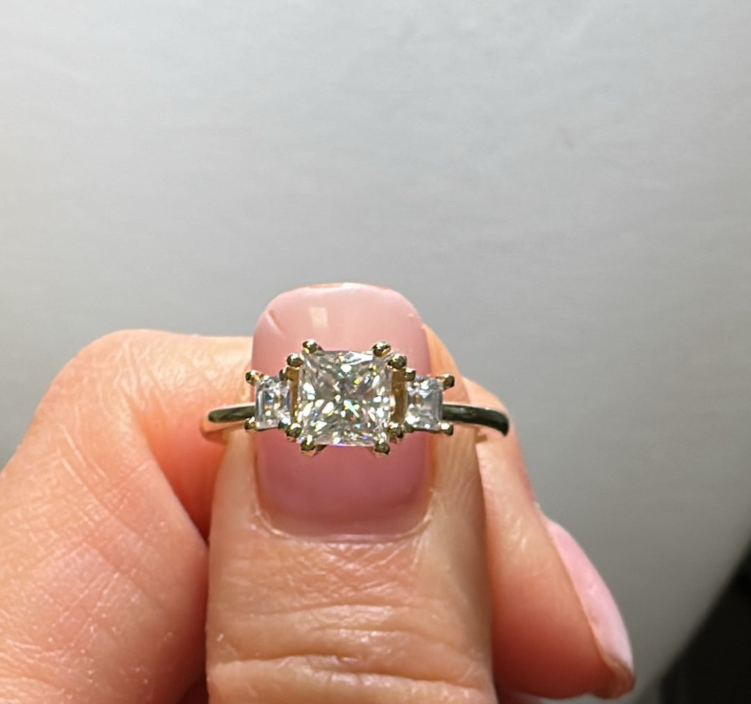 3-stone princess cut moissanite ring with 0.90CT center stone and two side stones, set in 14K gold.