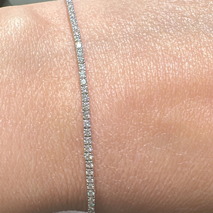 Close-up of a 14K white gold lab-grown diamond tennis bracelet with a four-prong, open-back basket-style setting, featuring 100 diamonds totaling 1.89 CT.
