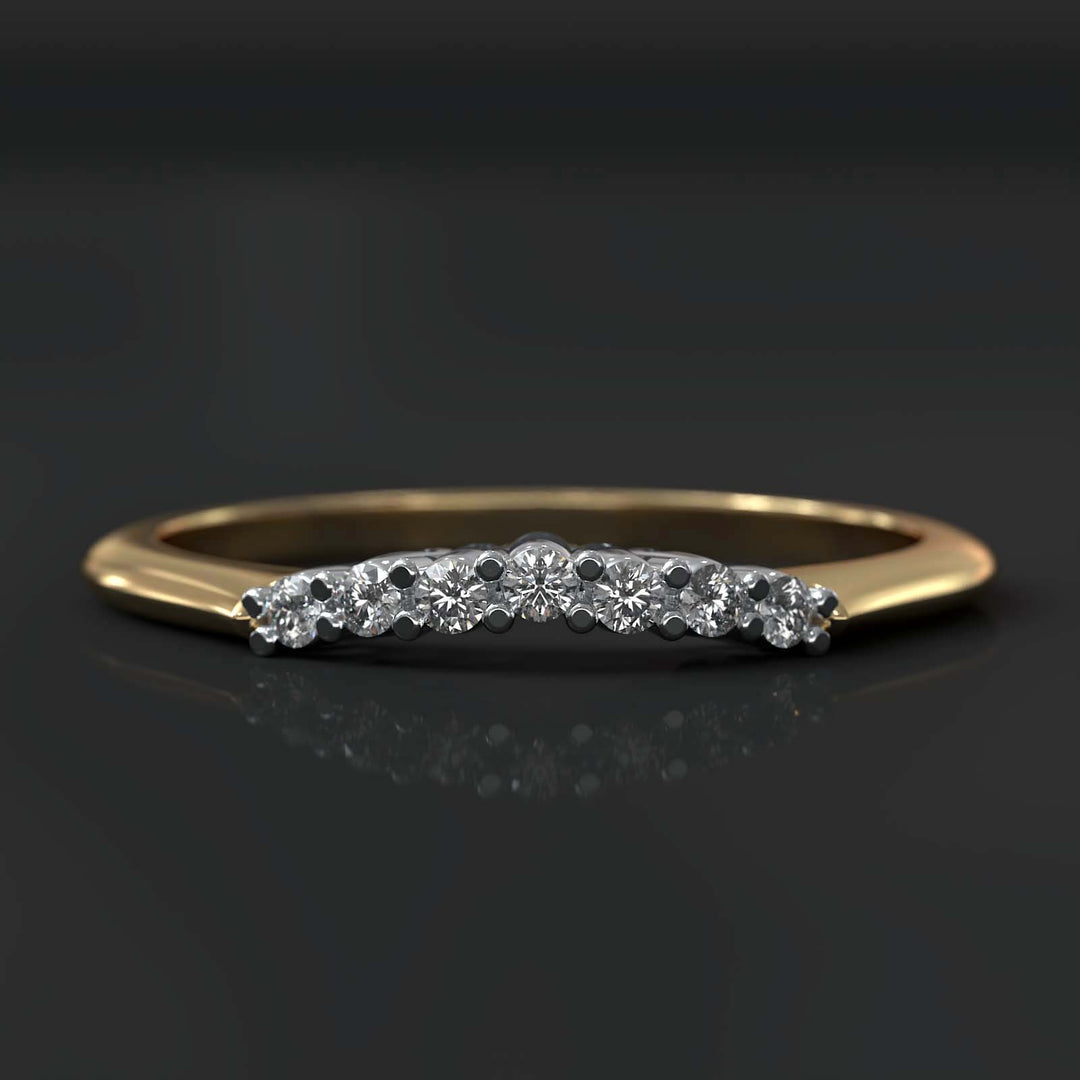 Curved wedding band with round diamonds in a custom secure setting.