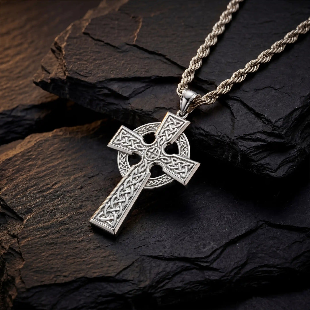Celtic knot cross pendant necklace with circular halo design displayed on black stone.