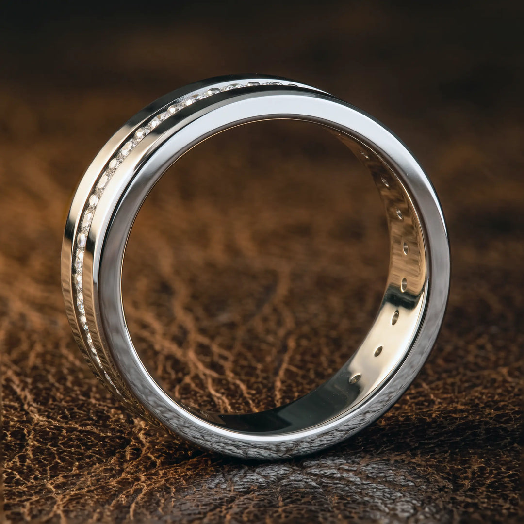 Channel set round lab-grown diamond wedding band with flat beveled profile displayed at an angle.