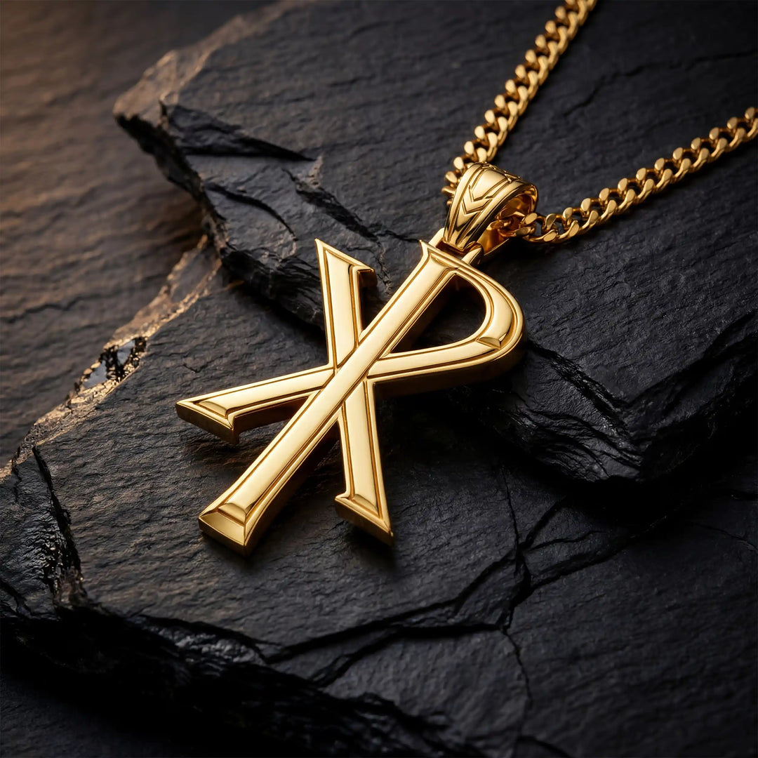 Chi Rho Christian cross pendant necklace displayed on black stone.