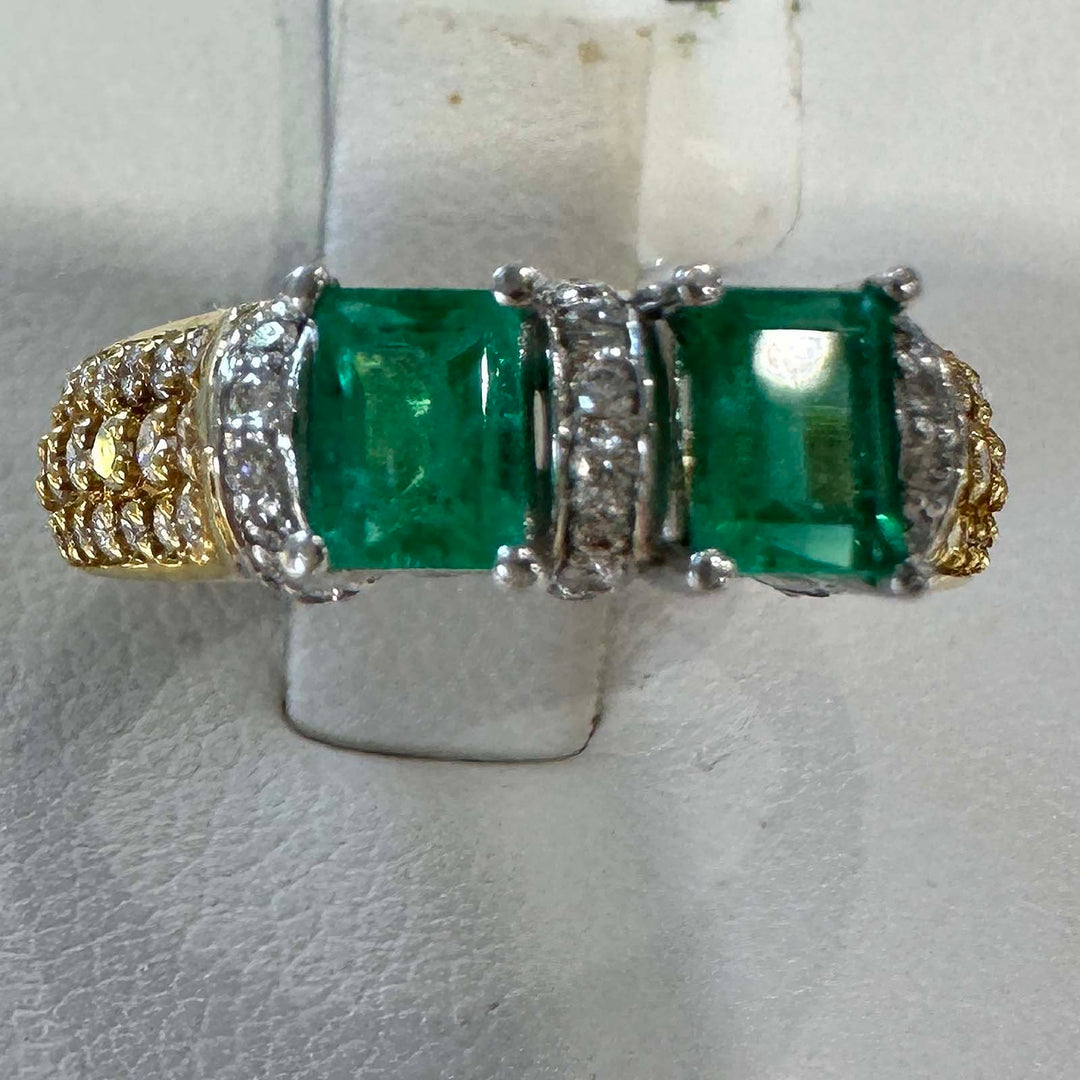 Custom double stone Colombian emerald ring in 18k yellow gold with natural diamonds.