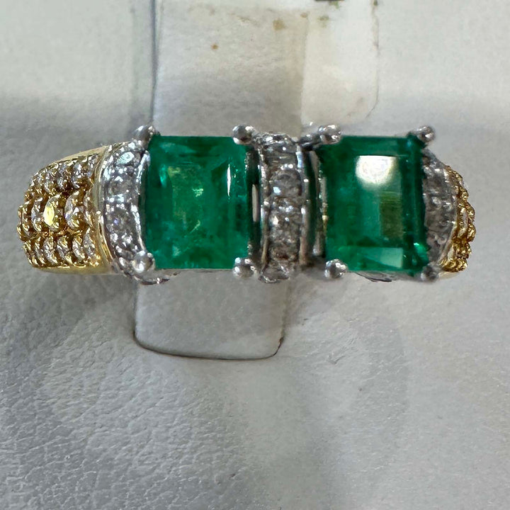 Custom double stone Colombian emerald ring in 18k yellow gold with natural diamonds.