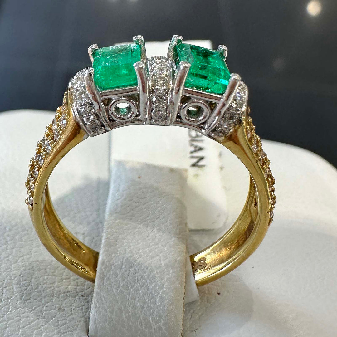 Custom double stone Colombian emerald ring in 18k yellow gold with natural diamonds.