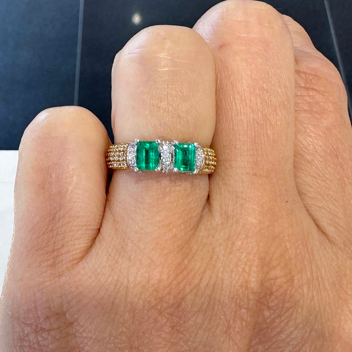 Custom double stone Colombian emerald ring in 18k yellow gold with natural diamonds.