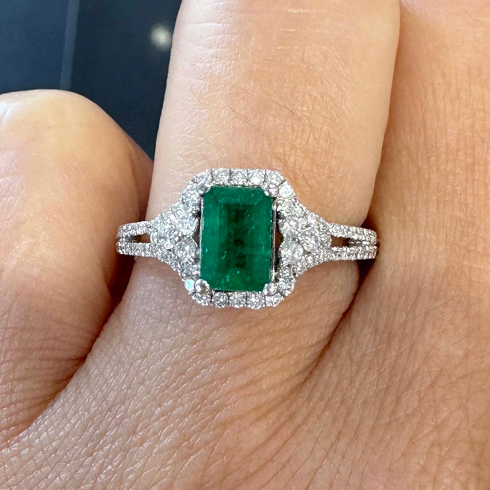Elegant Colombian emerald ring with diamond halo in 14k white gold.