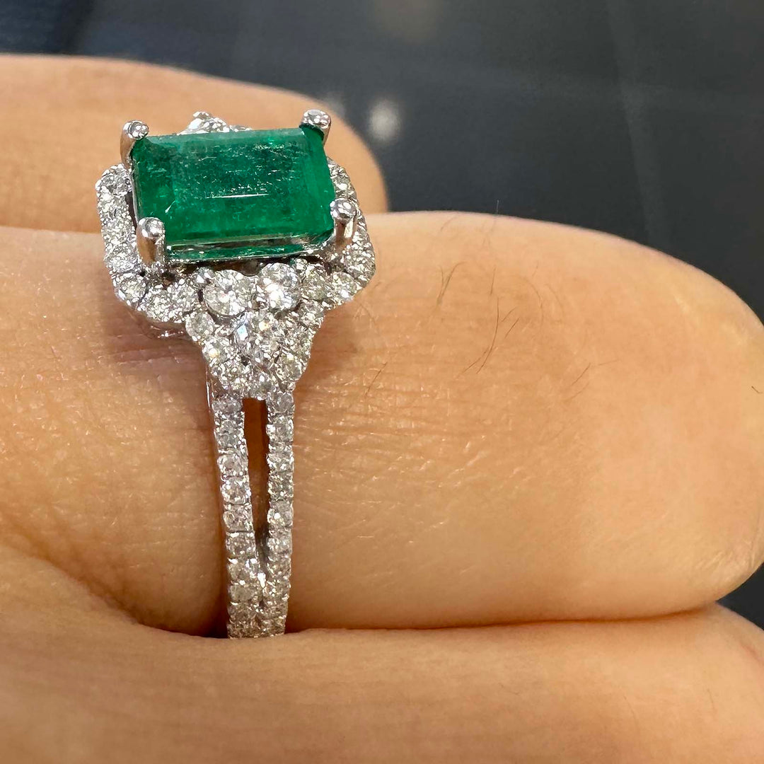 Elegant Colombian emerald ring with diamond halo in 14k white gold.