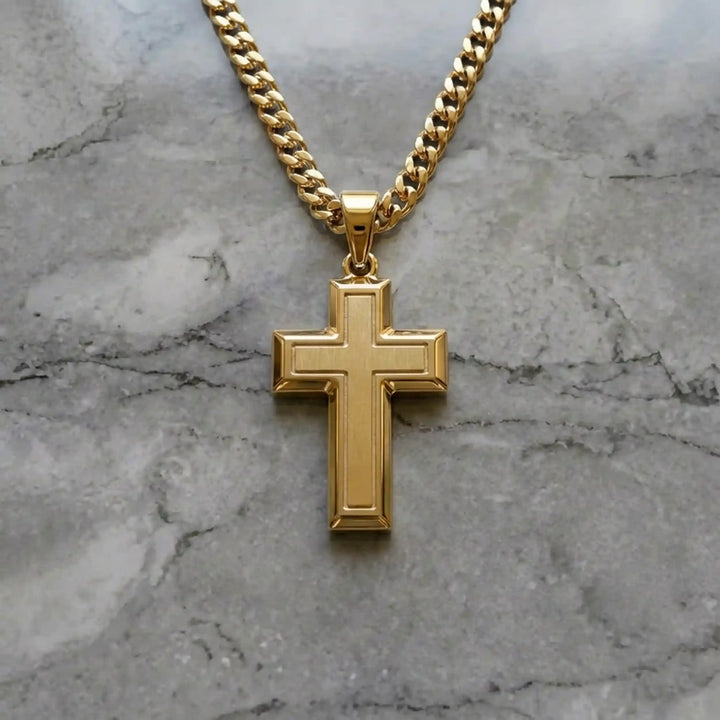 Hollow contemporary cross pendant displayed on chain over marble background.