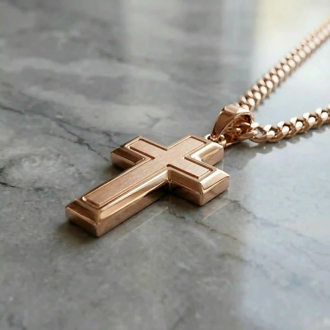 Hollow contemporary cross pendant displayed on chain over marble background.