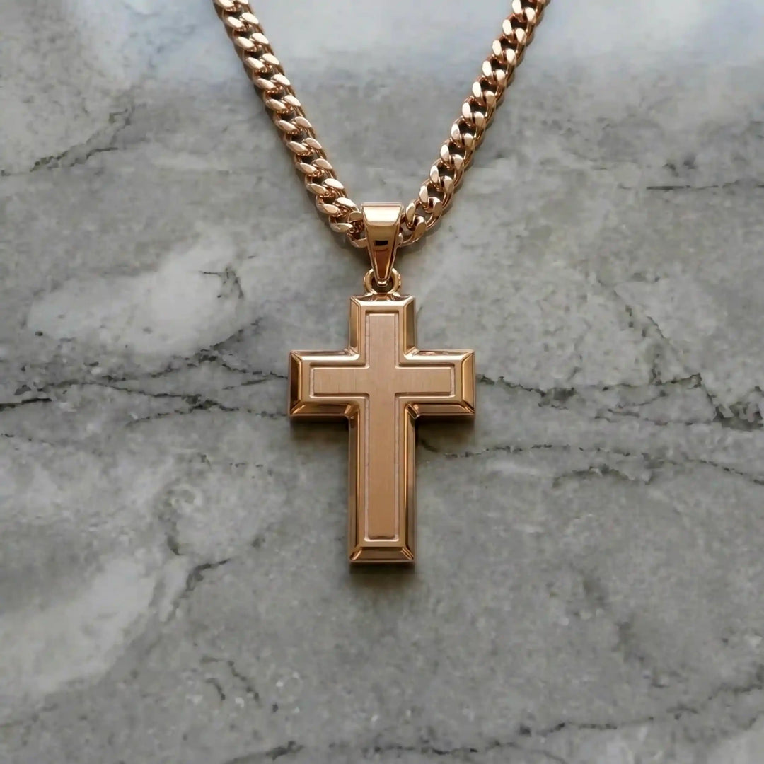 Hollow contemporary cross pendant displayed on chain over marble background.