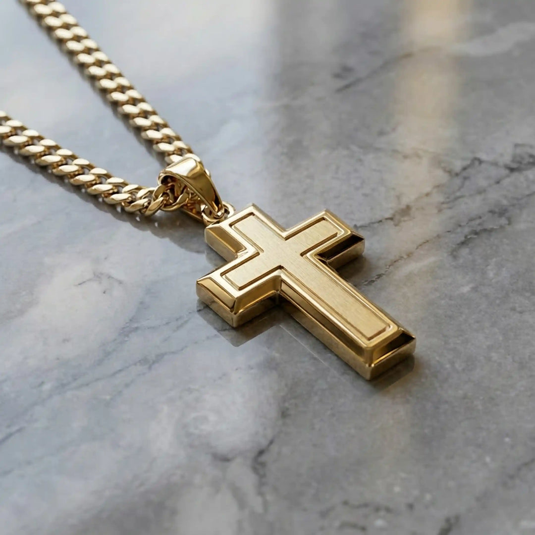 Hollow contemporary cross pendant displayed on chain over marble background.