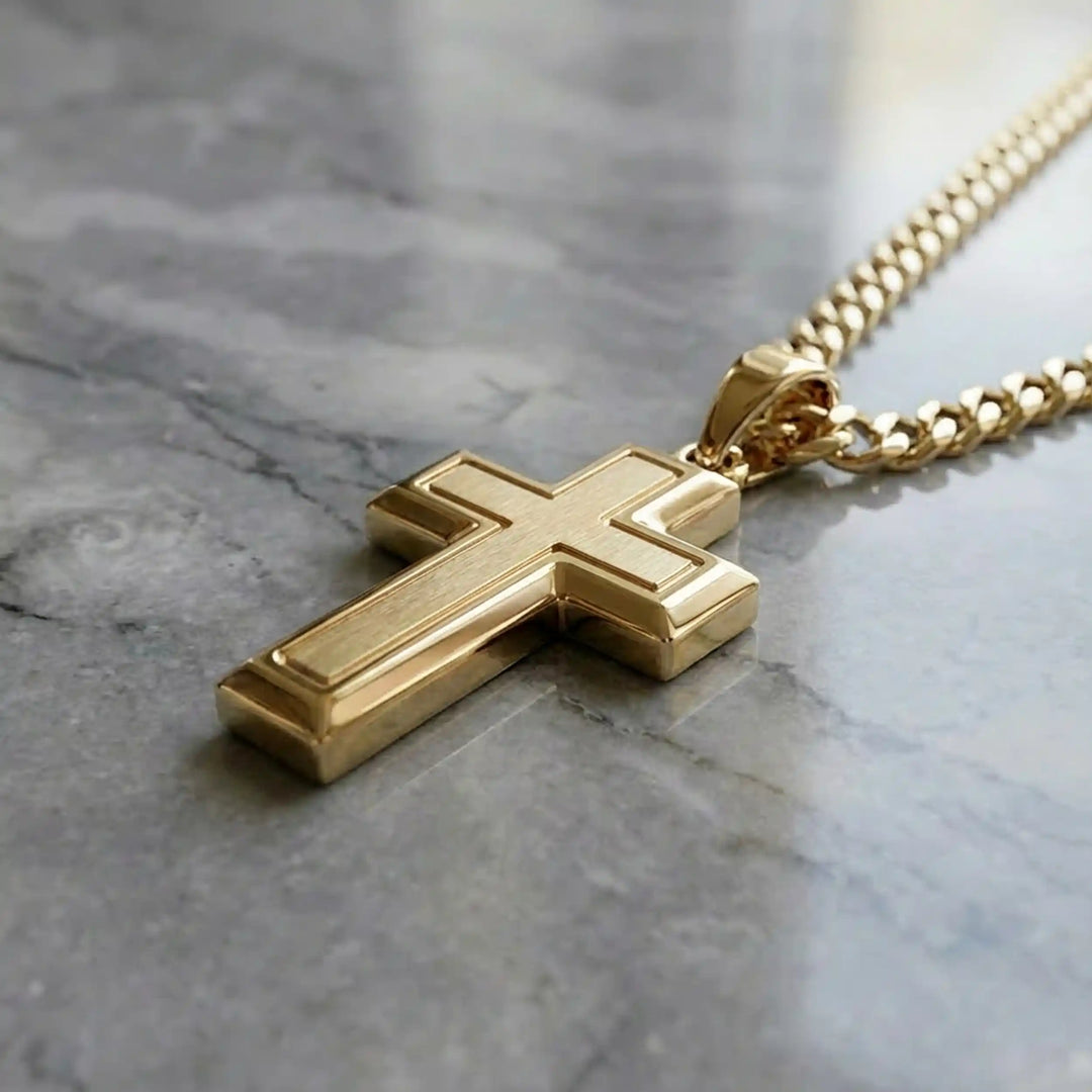 Hollow contemporary cross pendant displayed on chain over marble background.