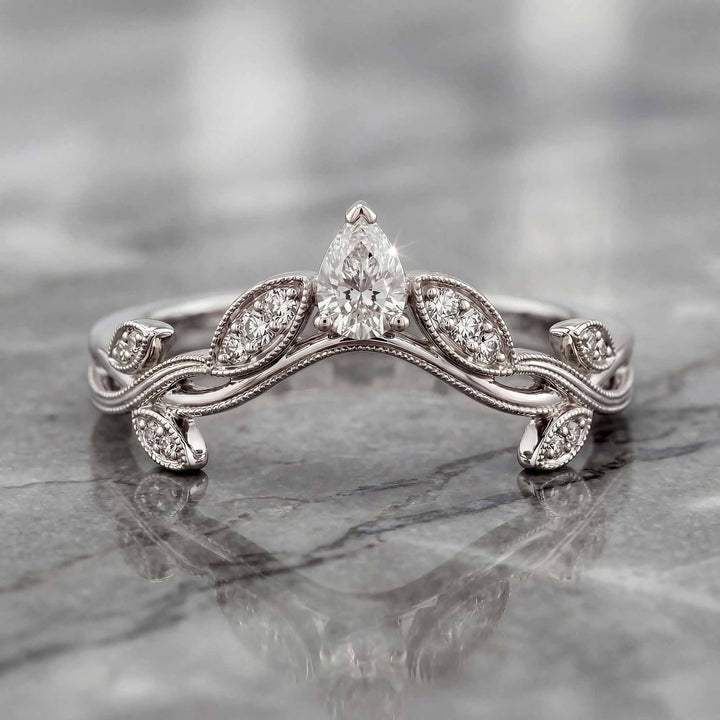 Curved wedding band with marquise and round lab-grown diamonds shown on reflective surface.