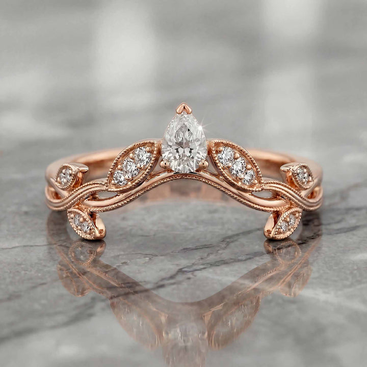 Curved wedding band with marquise and round lab-grown diamonds shown on reflective surface.