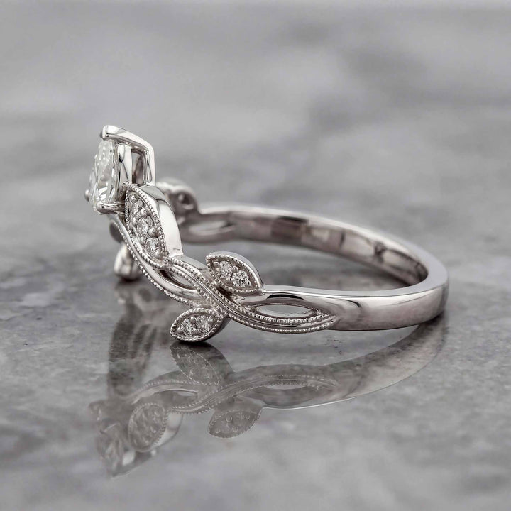 Curved wedding band with marquise and round lab-grown diamonds shown on reflective surface.