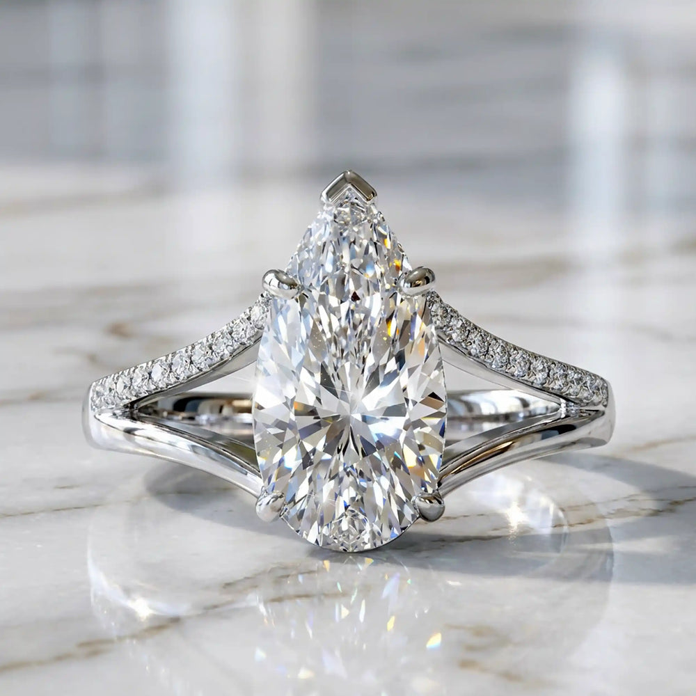 3 carat elongated pear lab diamond split shank engagement ring with pavé band on display.
