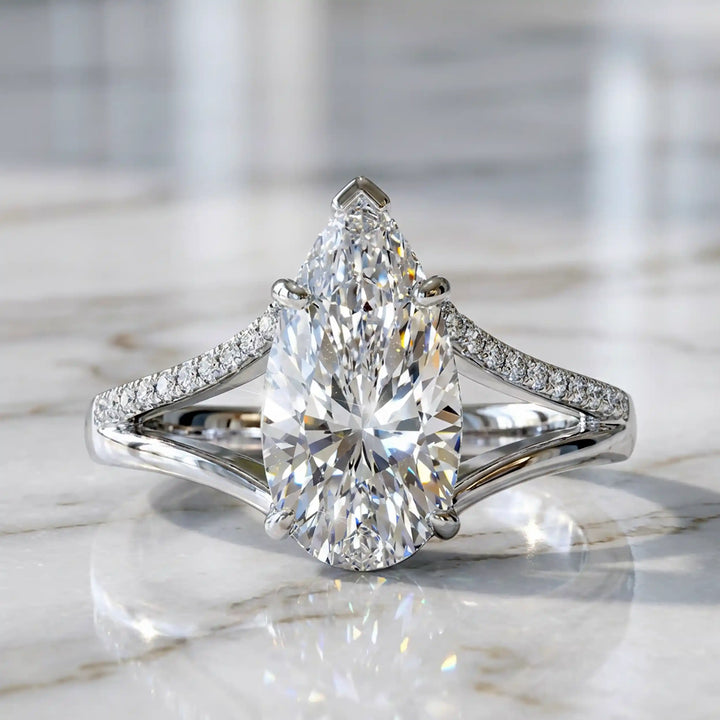 3 carat elongated pear lab diamond split shank engagement ring with pavé band on display.
