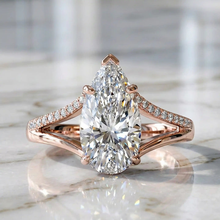 3 carat elongated pear lab diamond split shank engagement ring with pavé band on display.
