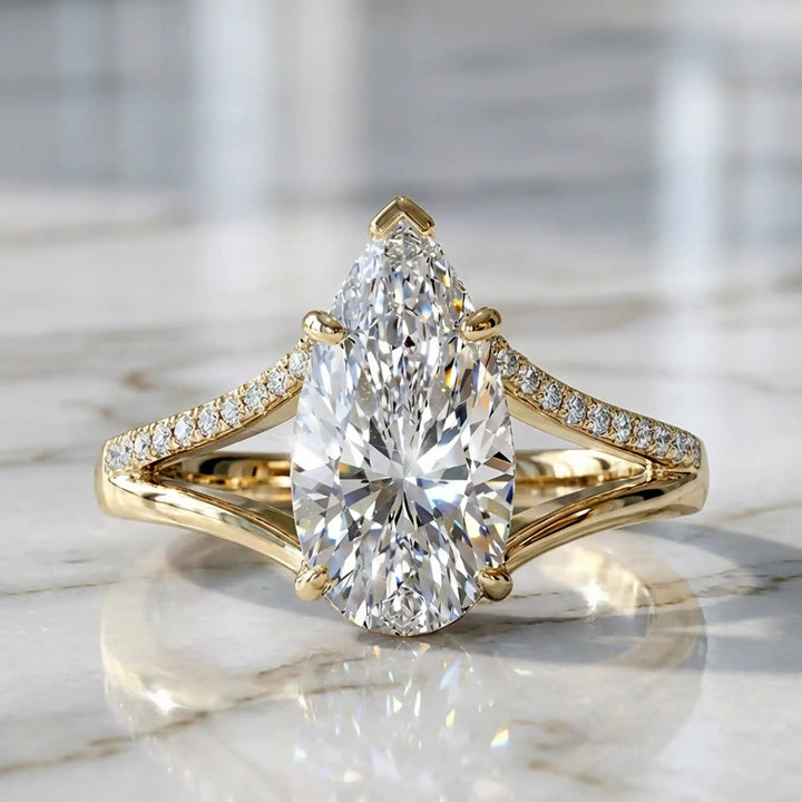 3 carat elongated pear lab diamond split shank engagement ring with pavé band on display.
