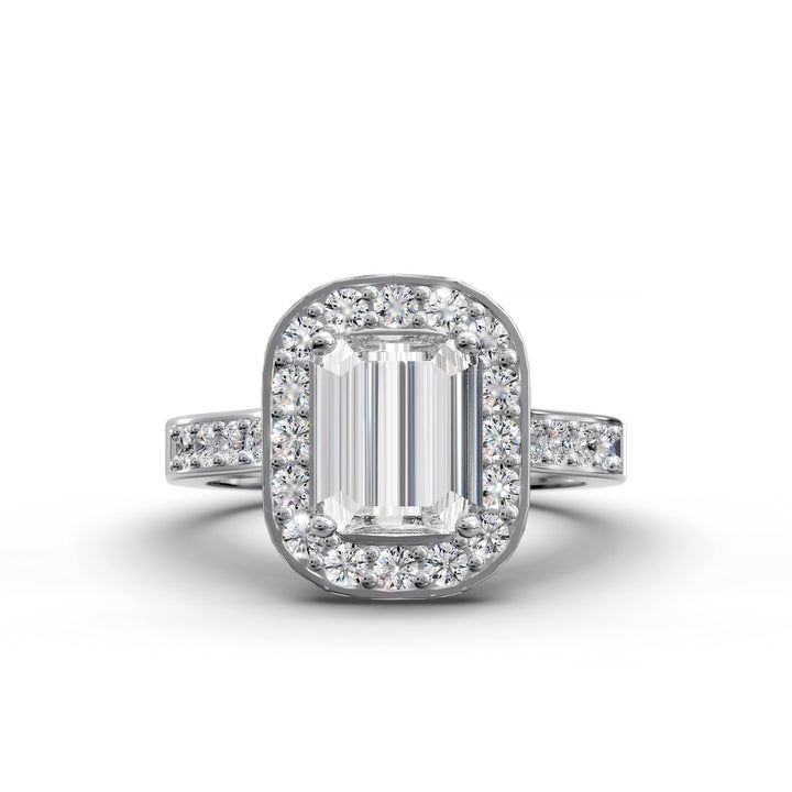 Emerald-cut diamond halo engagement ring with channel-set diamond band shown in studio lighting.