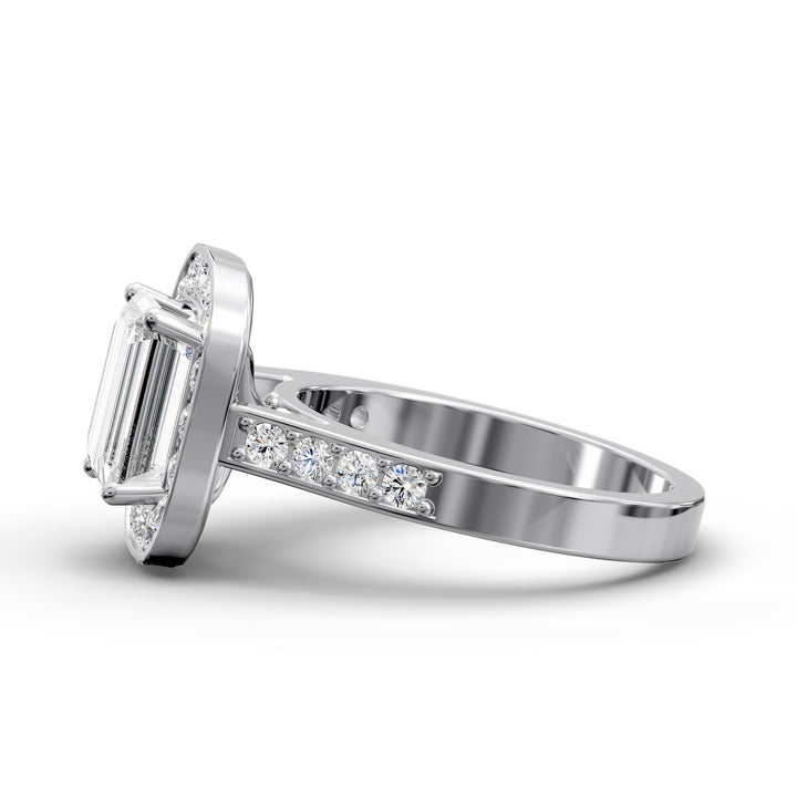 Emerald-cut diamond halo engagement ring with channel-set diamond band shown in studio lighting.