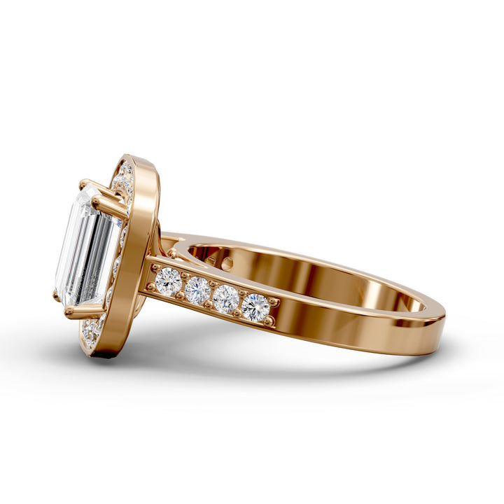 Emerald-cut diamond halo engagement ring with channel-set diamond band shown in studio lighting.