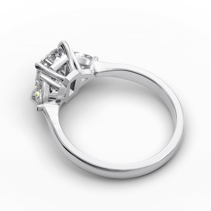 emerald-cut three-stone engagement ring with trapezoid side diamonds and tapered band shown from multiple angles