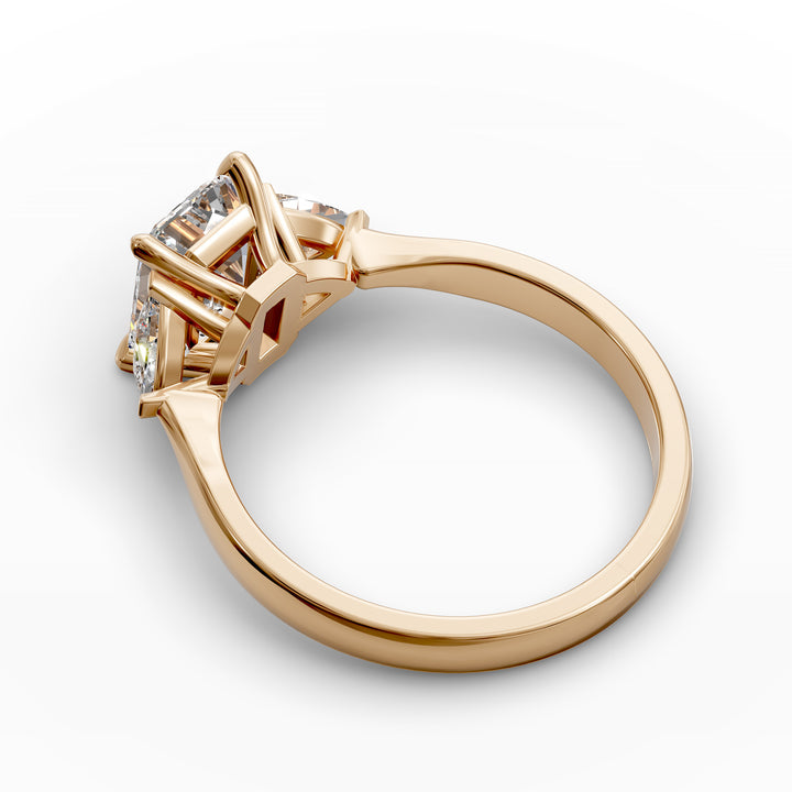 emerald-cut three-stone engagement ring with trapezoid side diamonds and tapered band shown from multiple angles