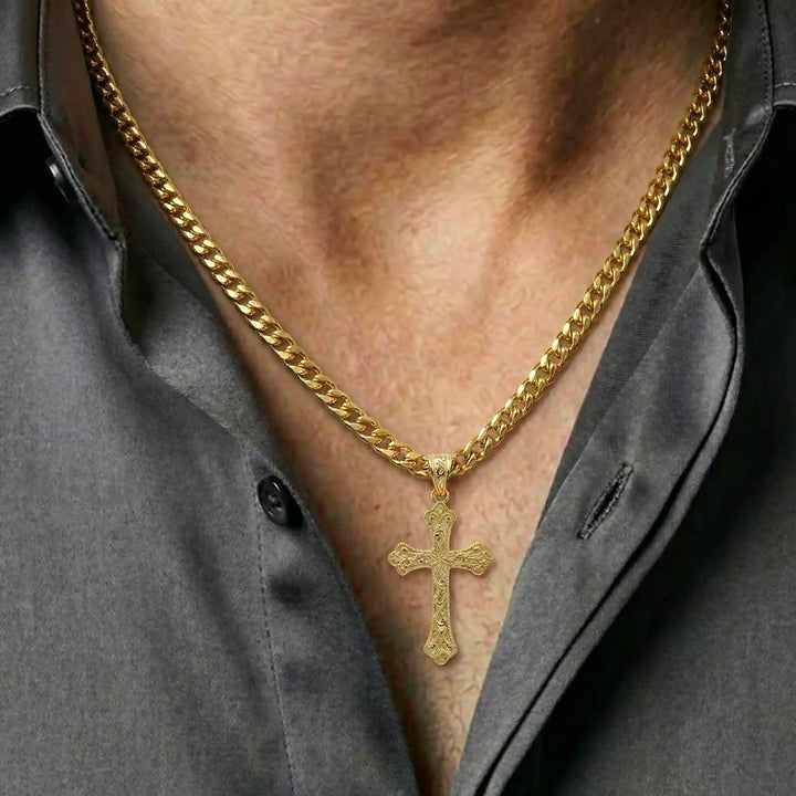 Ornate Gothic cross pendant necklace with engraved vintage-style detailing displayed on chest.