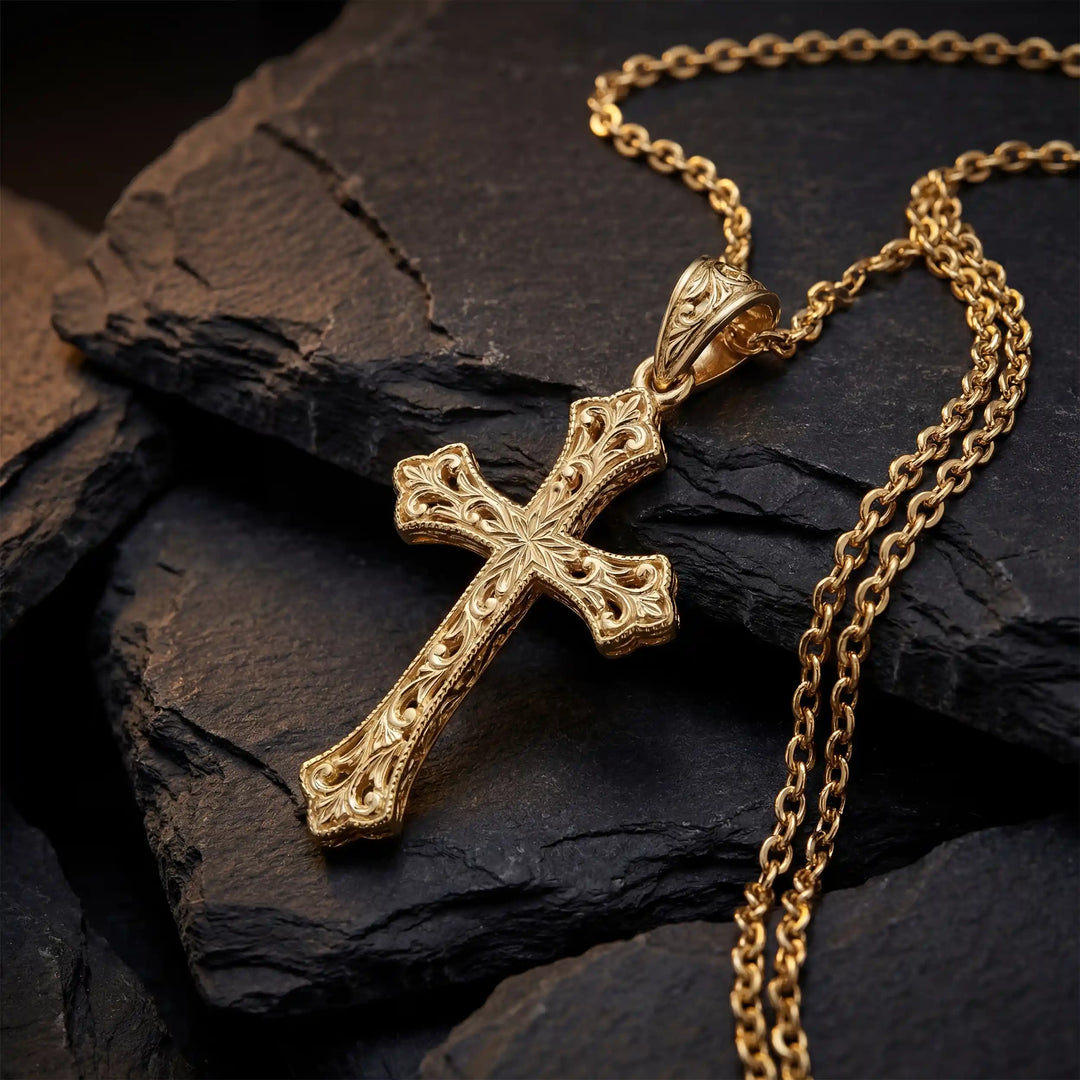 Ornate Gothic cross pendant necklace with engraved vintage-style detailing displayed on black stone.