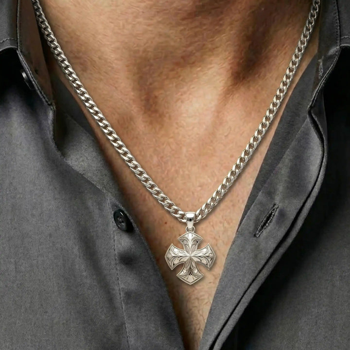 Maltese cross pendant with engraved ornamental design displayed on white background.