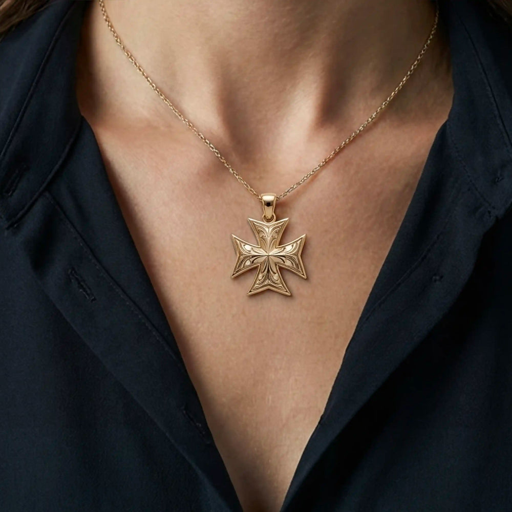 Maltese cross pendant with engraved ornamental design displayed on chest.