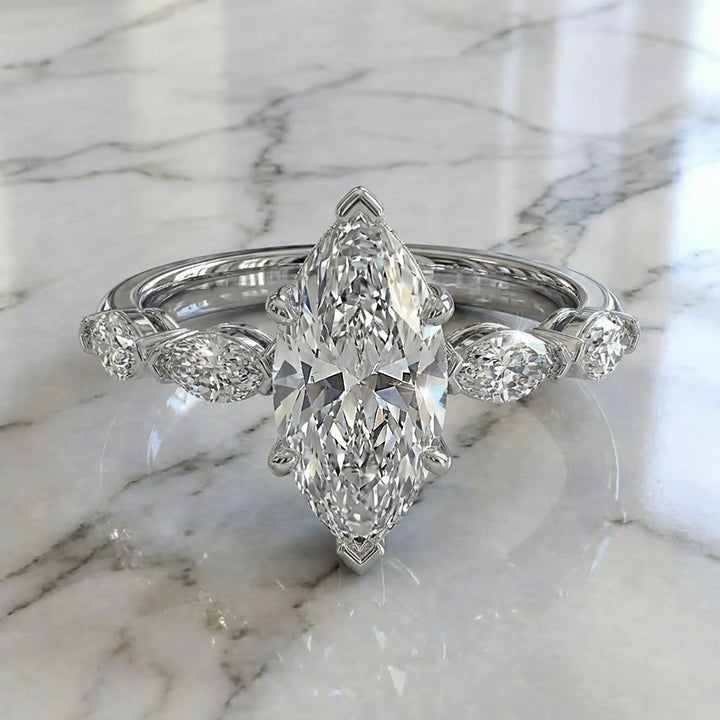 2 carat marquise lab diamond engagement ring with hidden halo and marquise accent band on marbel.
