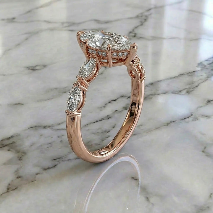 2 carat marquise lab diamond engagement ring with hidden halo and marquise accent band on marbel.
