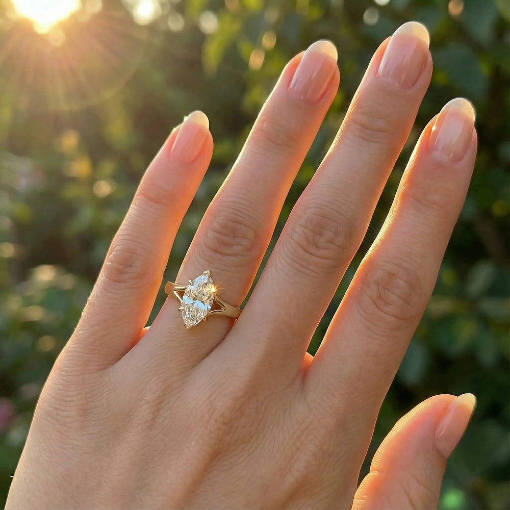 Marquise-cut lab-grown diamond split shank solitaire ring displayed on hand.

