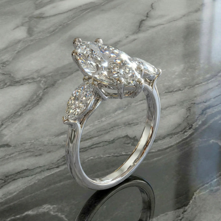 Marquise three-stone lab-grown diamond engagement ring shown on reflective surface.
