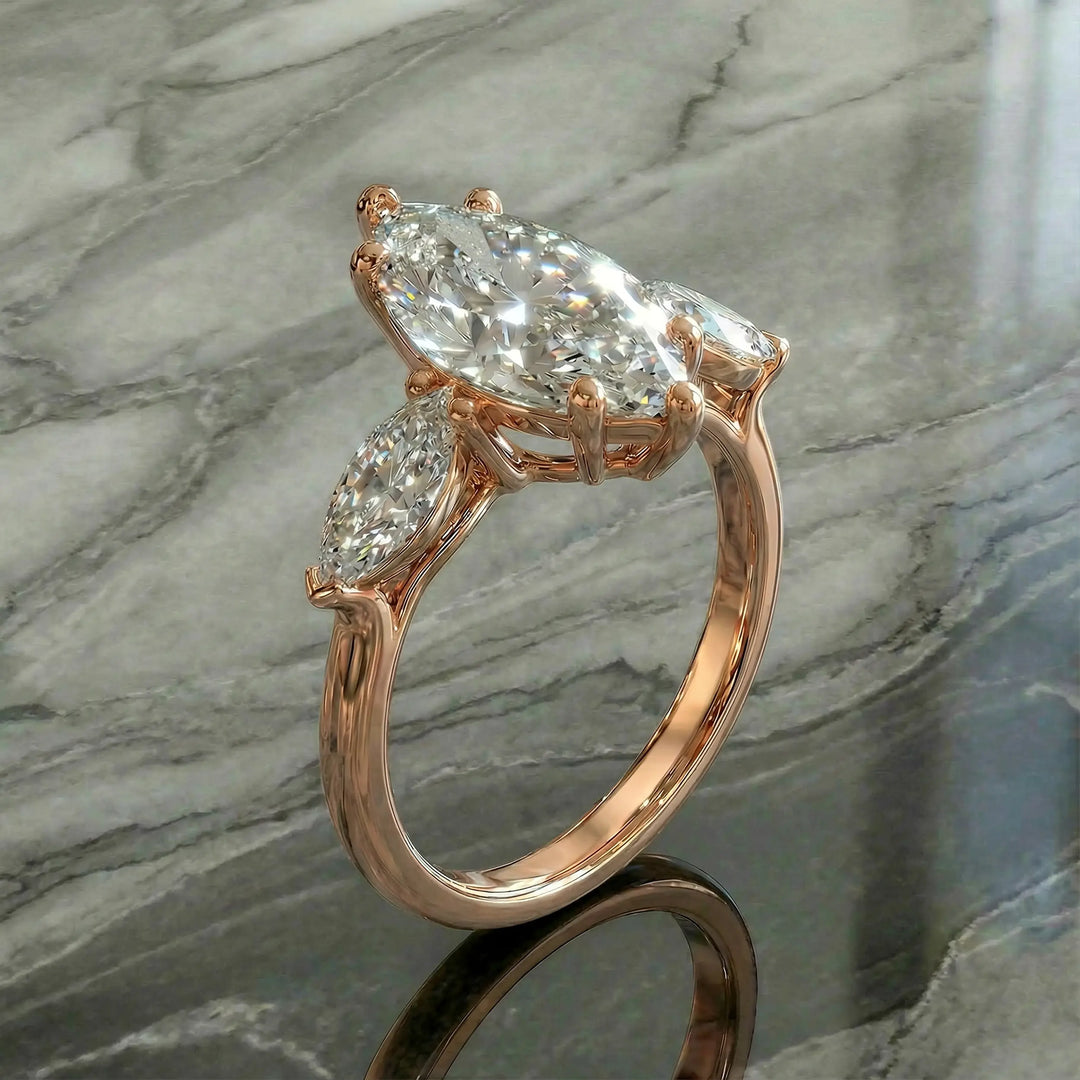 Marquise three-stone lab-grown diamond engagement ring shown on reflective surface.

