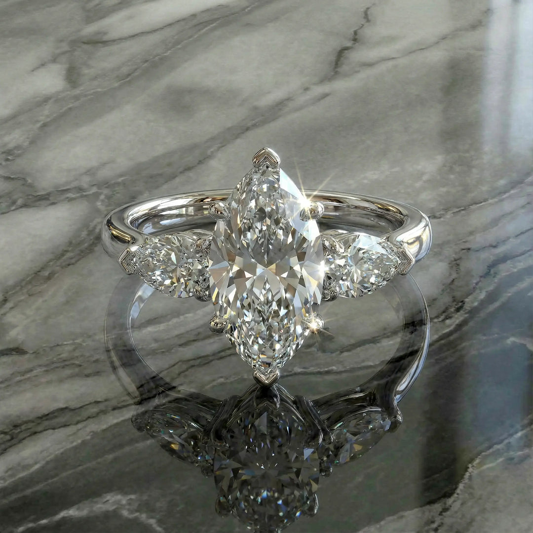 Marquise three-stone lab-grown diamond engagement ring shown on reflective surface.

