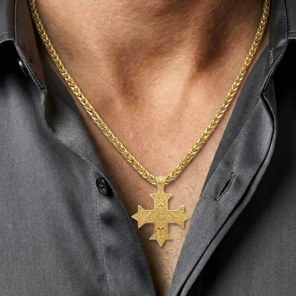 Ornate Coptic cross pendant with intricate filigree pattern displayed on chest
