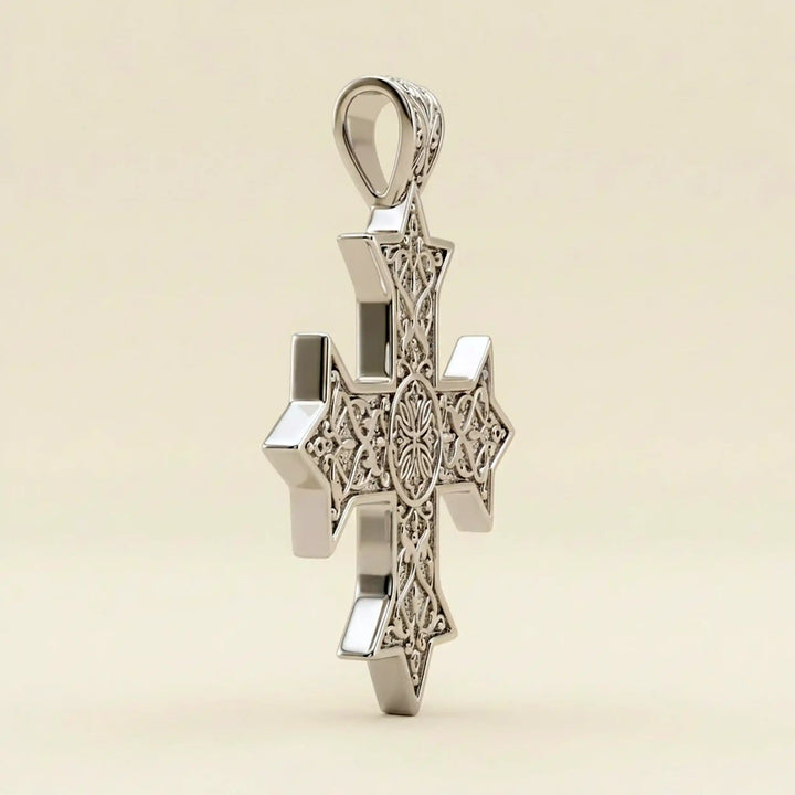Ornate Coptic cross pendant with intricate filigree pattern displayed on neutral background.
