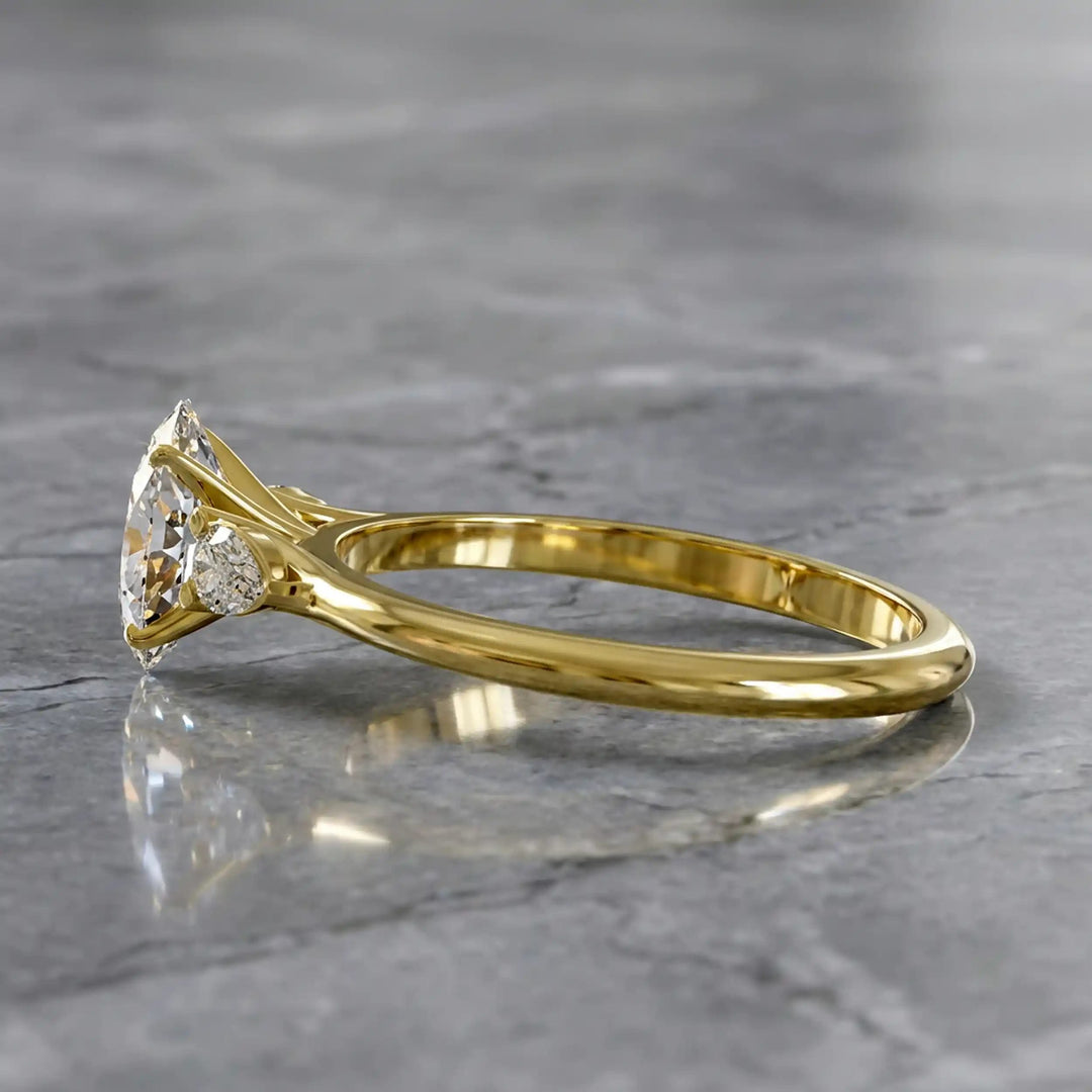 Oval diamond engagement ring with pear-shaped side stones front view.