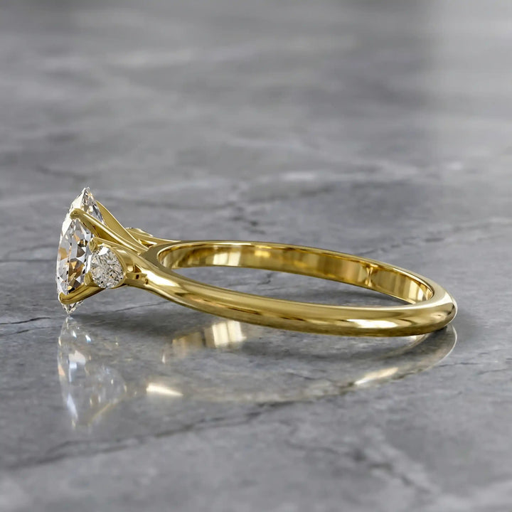 Oval diamond engagement ring with pear-shaped side stones front view.