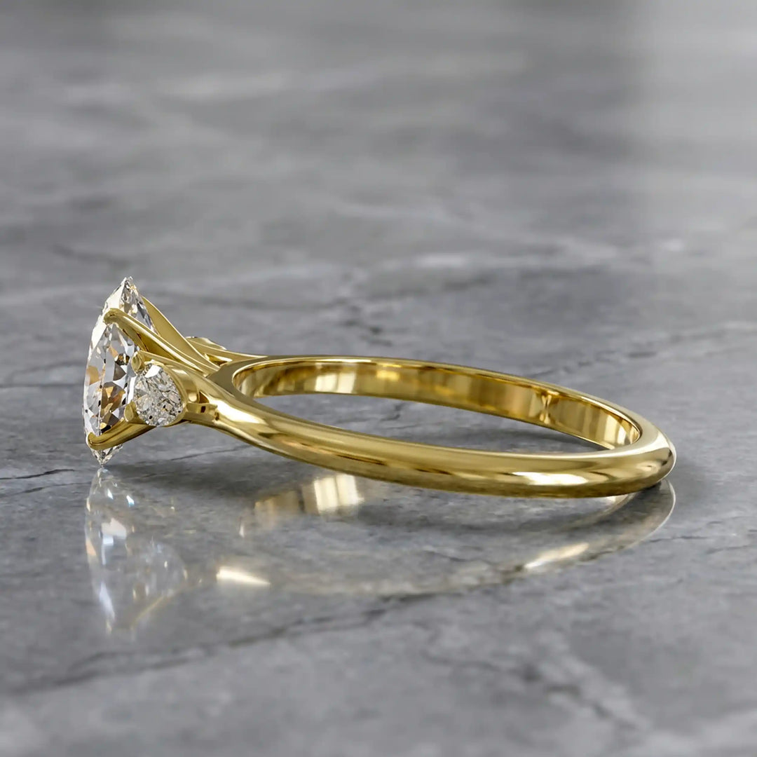 Oval diamond engagement ring with pear-shaped side stones front view.