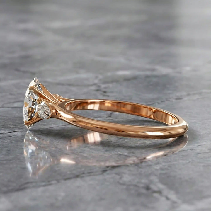 Oval diamond engagement ring with pear-shaped side stones front view.