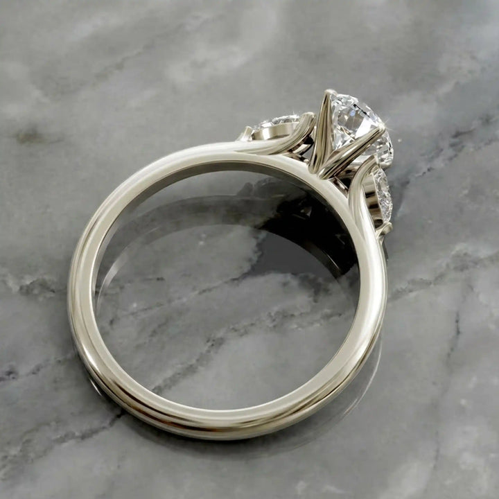 Oval diamond engagement ring with pear-shaped side stones front view.
